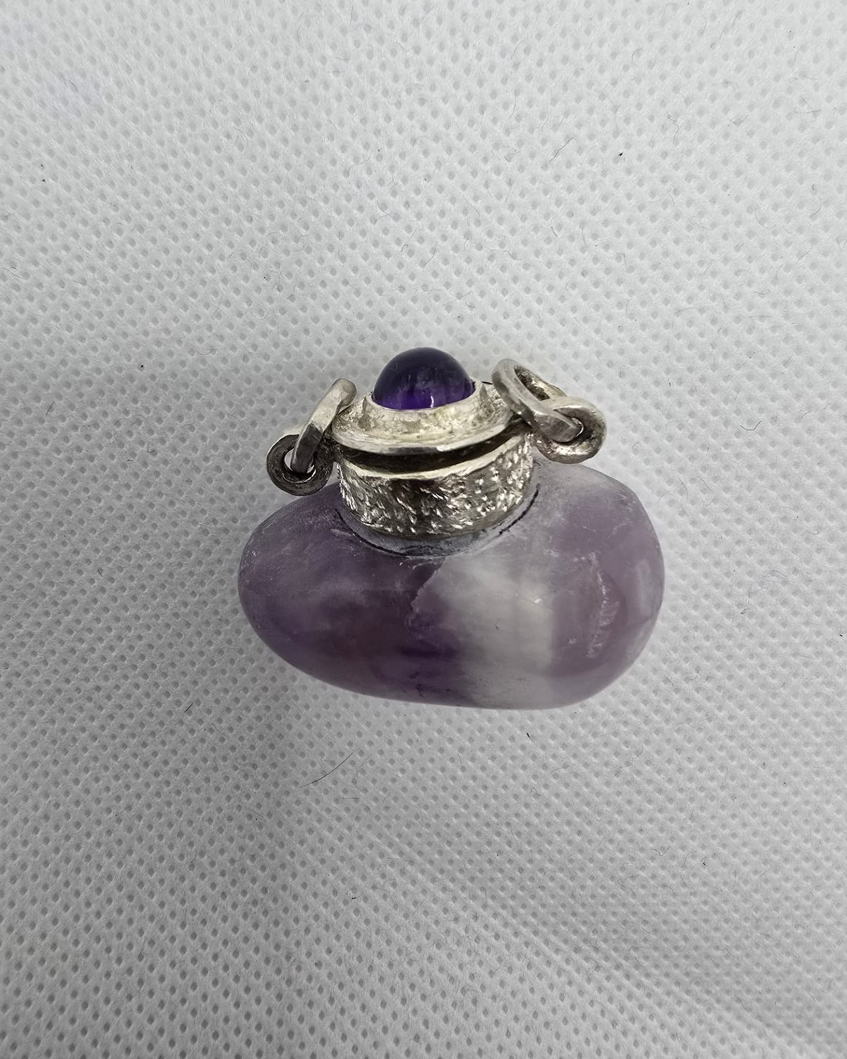 Amethyst vessel with textured silver collar and amethyst cabochon stopper, front view