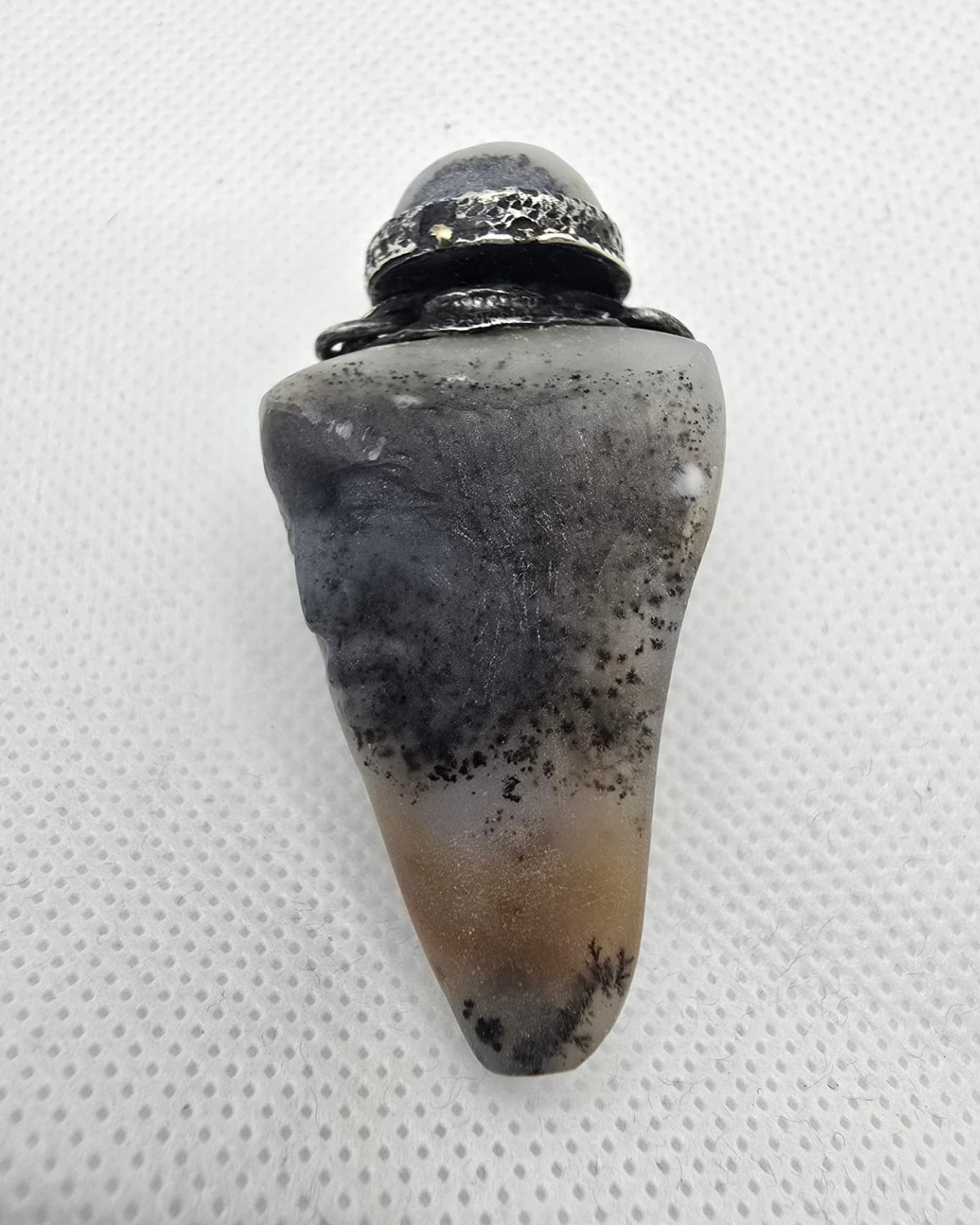 Hand-carved dendritic grey stone vessel with silver collar, front view