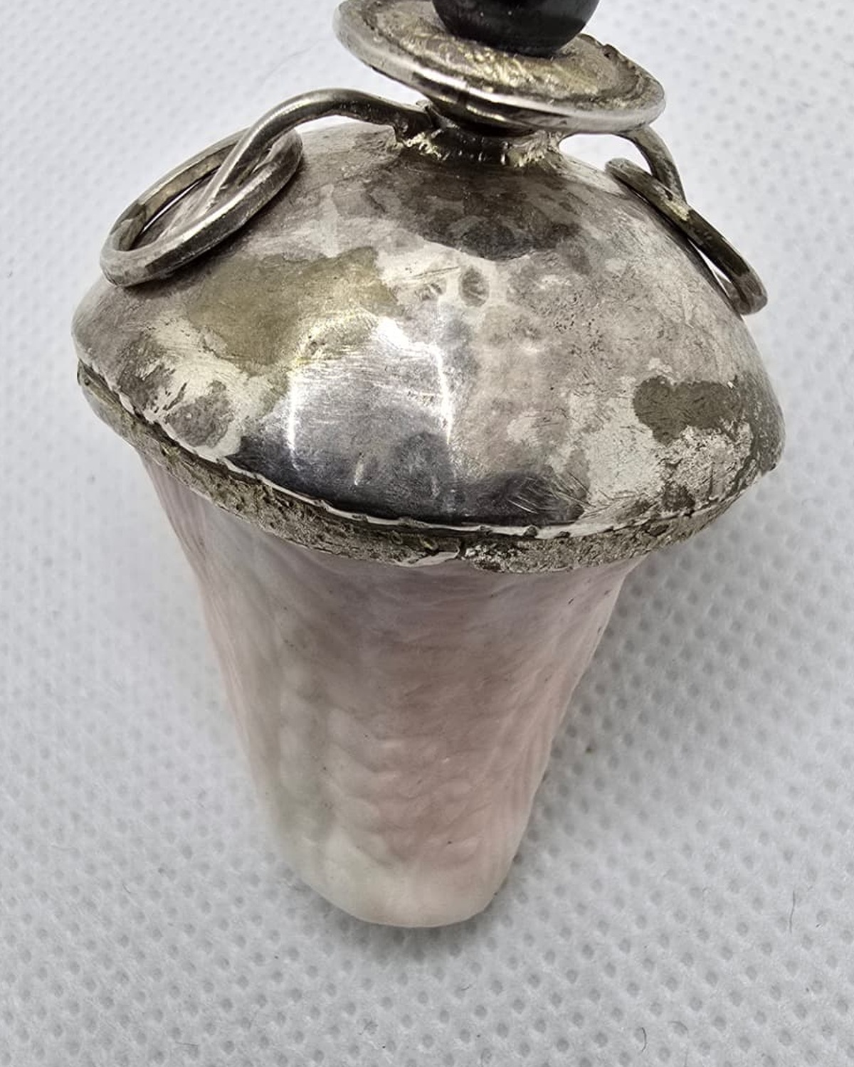 Rose quartz vessel with hammered silver cap and hematite finial, reverse view