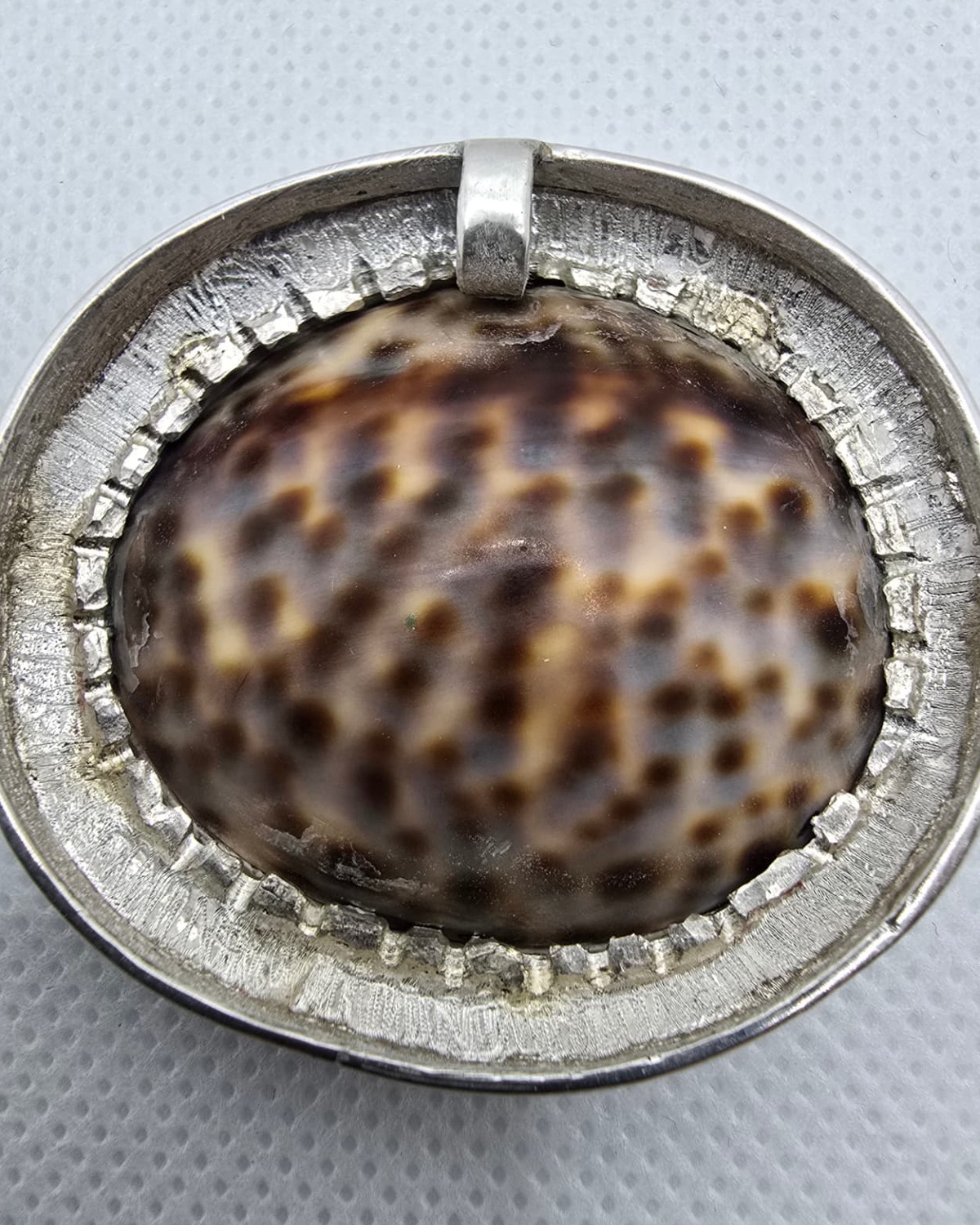 The Dreamer — reverse showing the naturally spotted brown, cream and white sea shell within the handmade silver setting