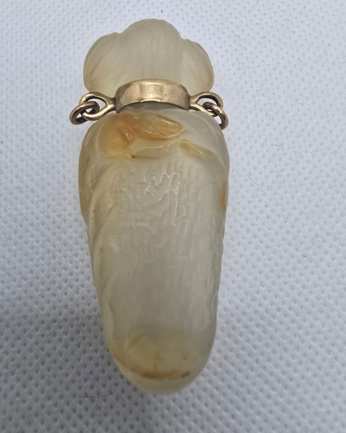 Pale jade vessel with gold collar and lobed carved stopper, front view