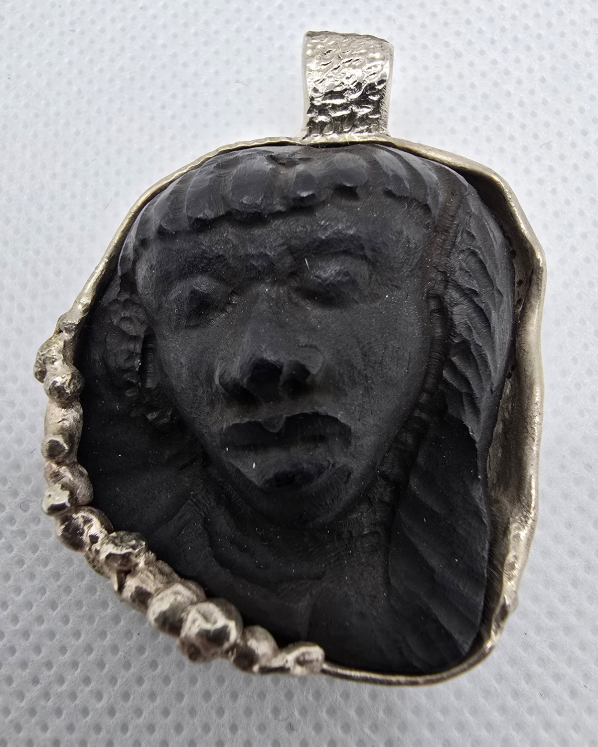The Daughter of the Earth — female portrait hand-carved in deep relief from black jet within an irregular handmade silver setting with a large textured bail