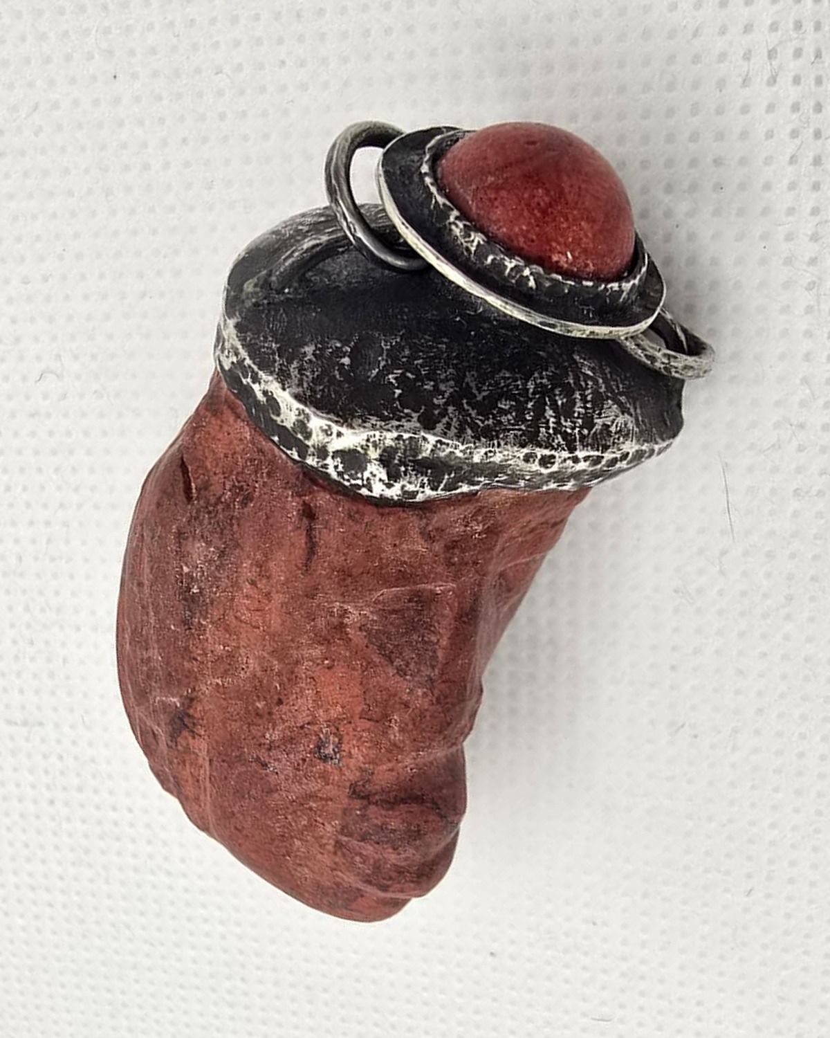 Hand-carved red stone vessel with silver mount, reverse view