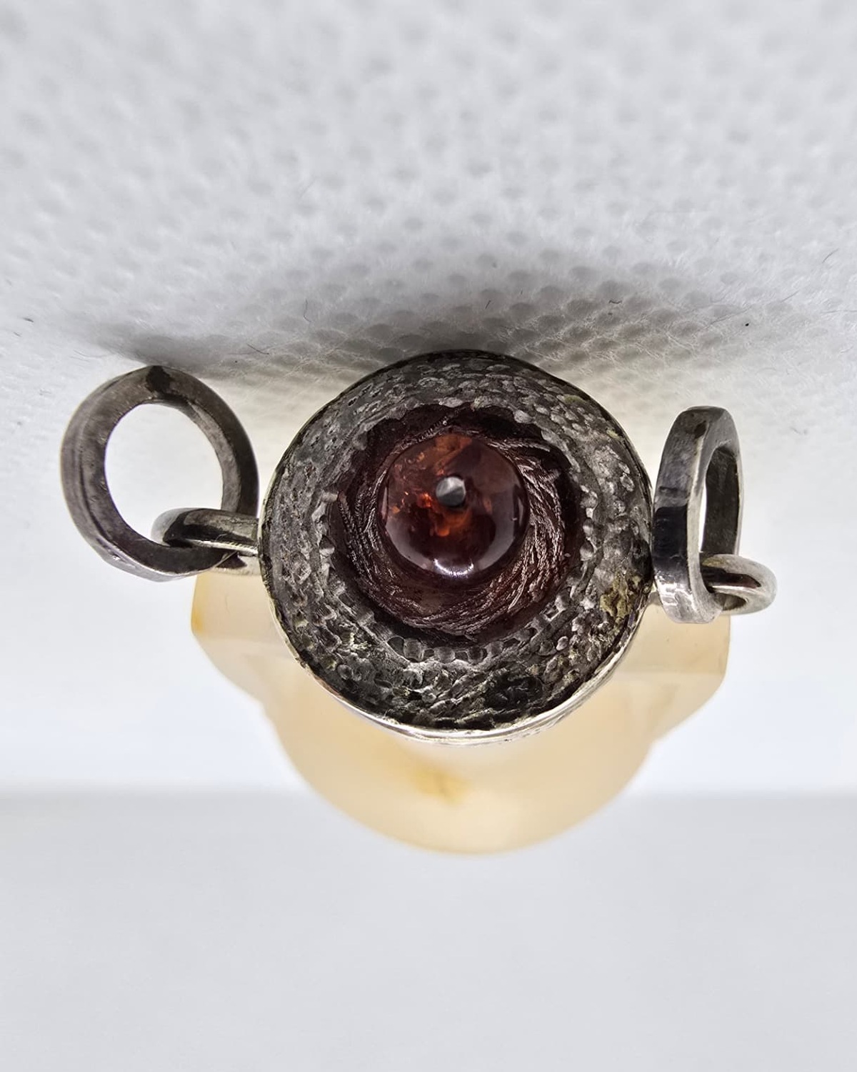 Frosted agate amphora seen from above, silver collar set with amber cabochon