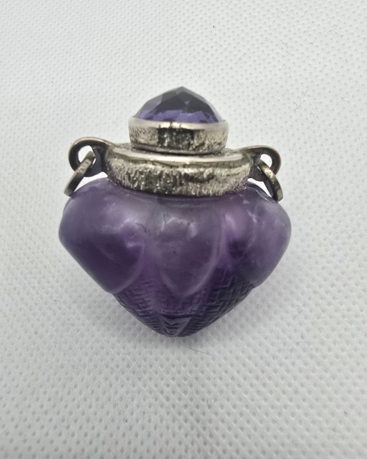 Amethyst vessel with silver collar and faceted amethyst stopper, front view