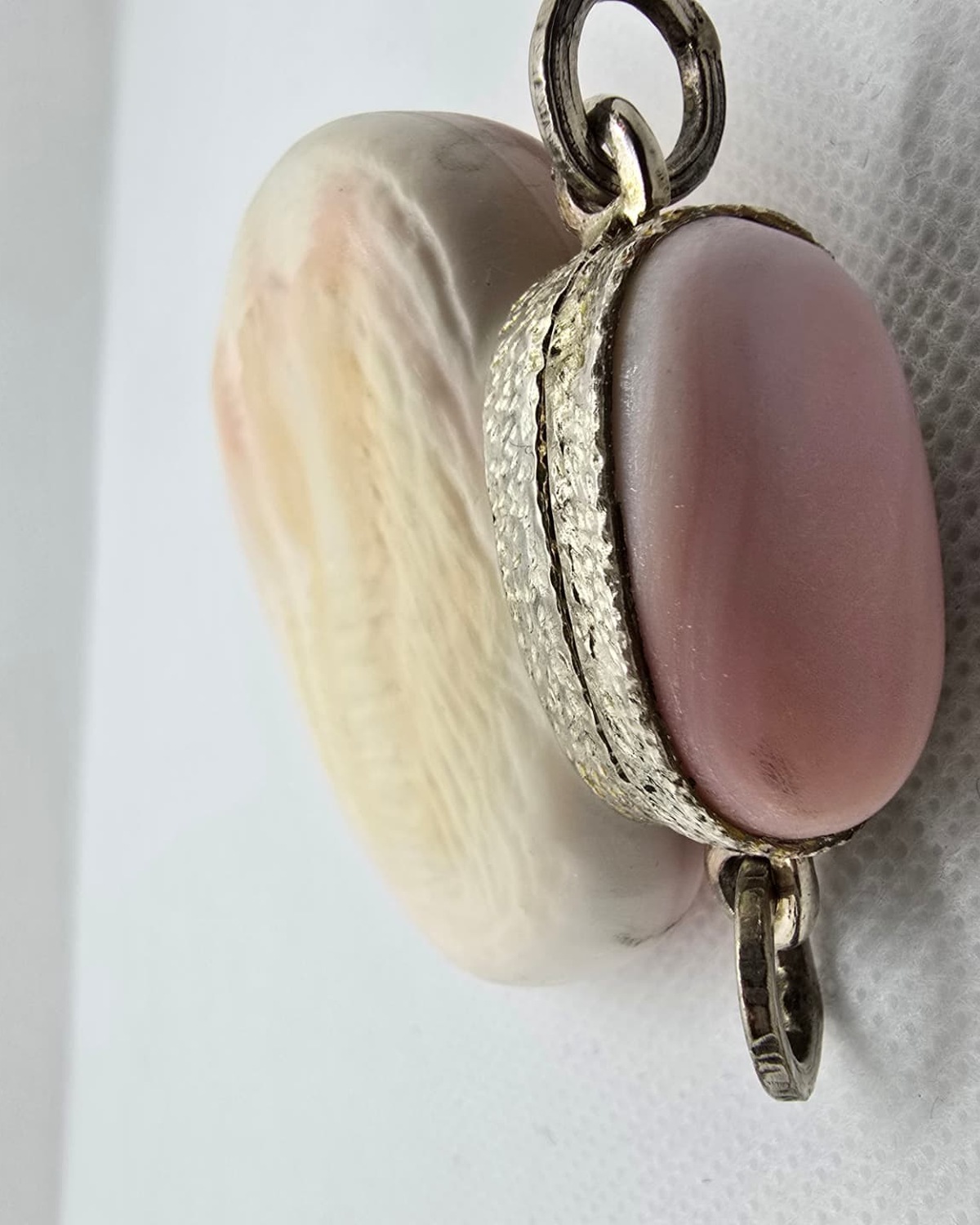 Pink sea shell vessel with silver mount, profile view