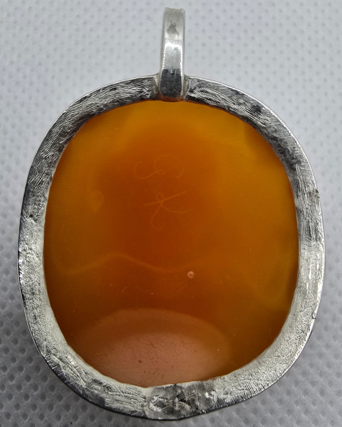 The Wanderer — reverse showing the warm translucent natural shell within a textured handmade silver surround and pendant bail