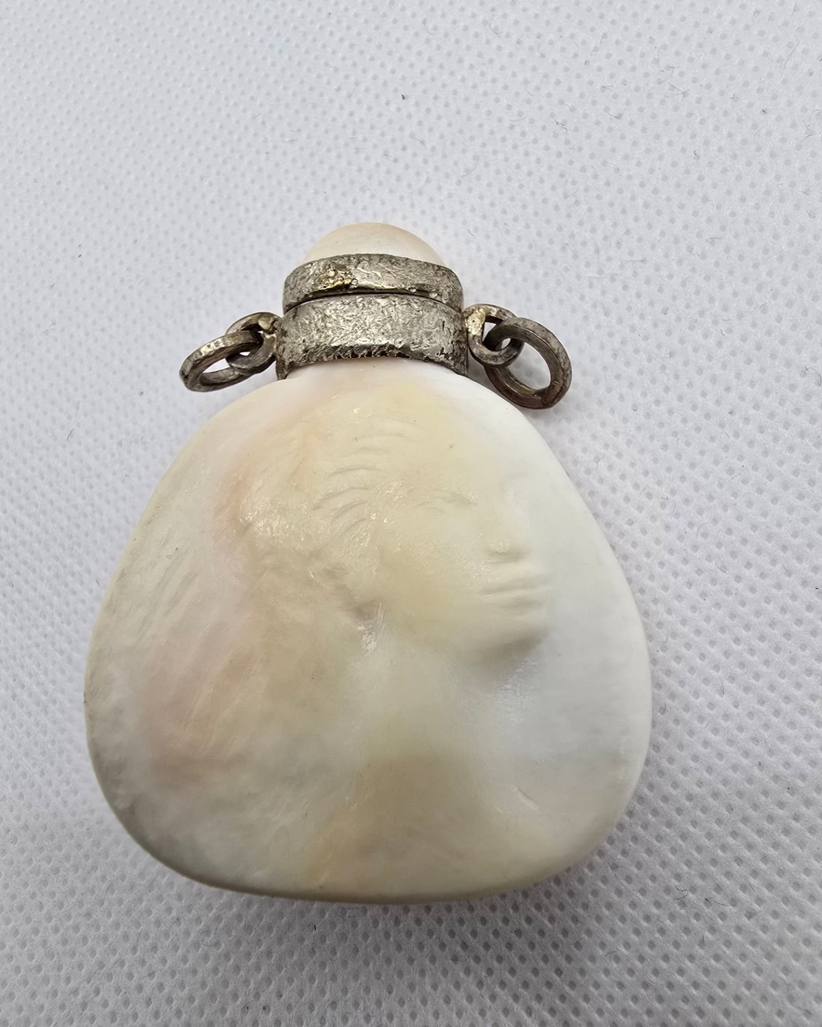 Carved mother-of-pearl shell vessel with silver mounts, front view