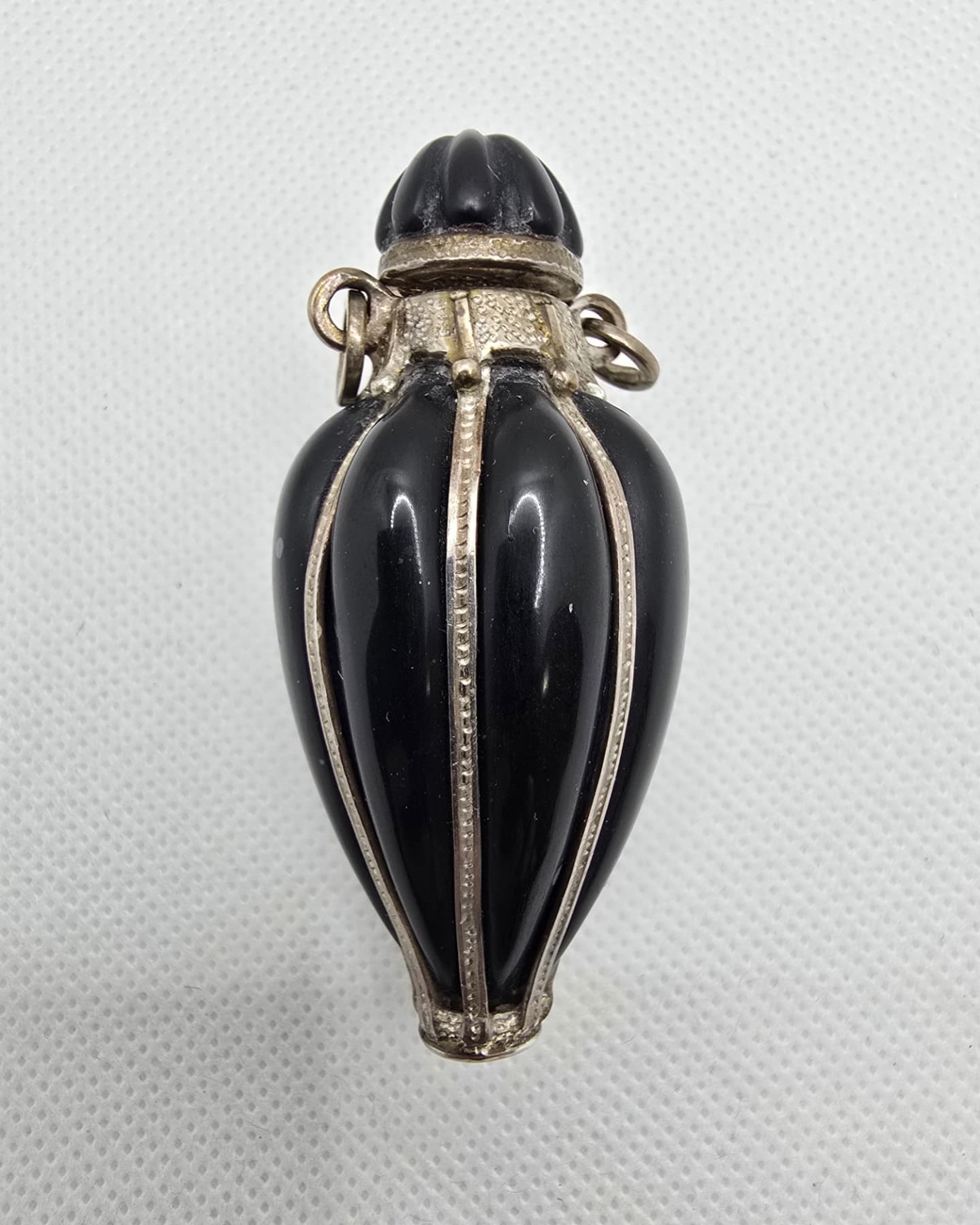 Black fluted onyx amphora with silver ribs and carved stopper, front view