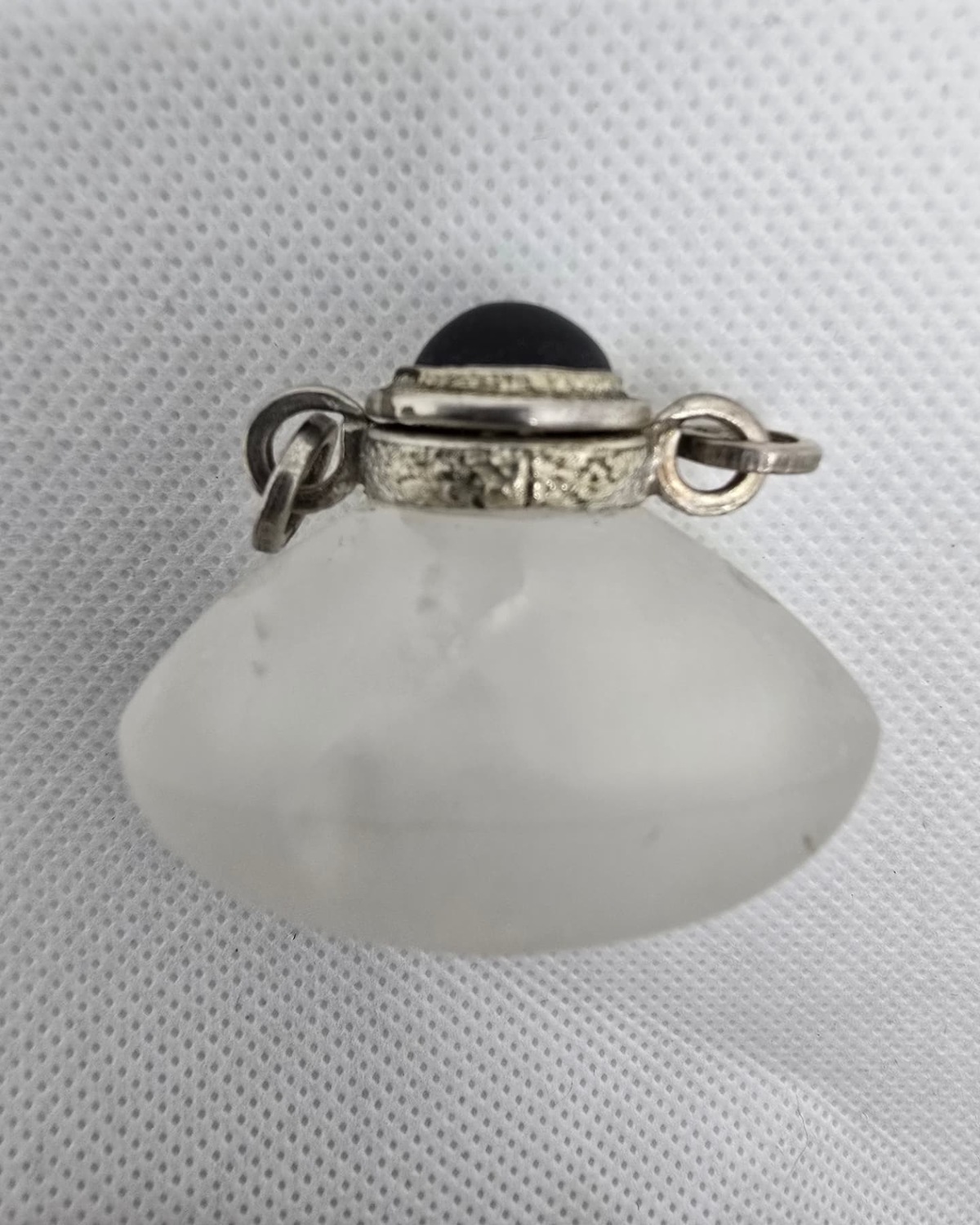 Frosted rock crystal heart vessel in profile with silver collar and dark cabochon stopper