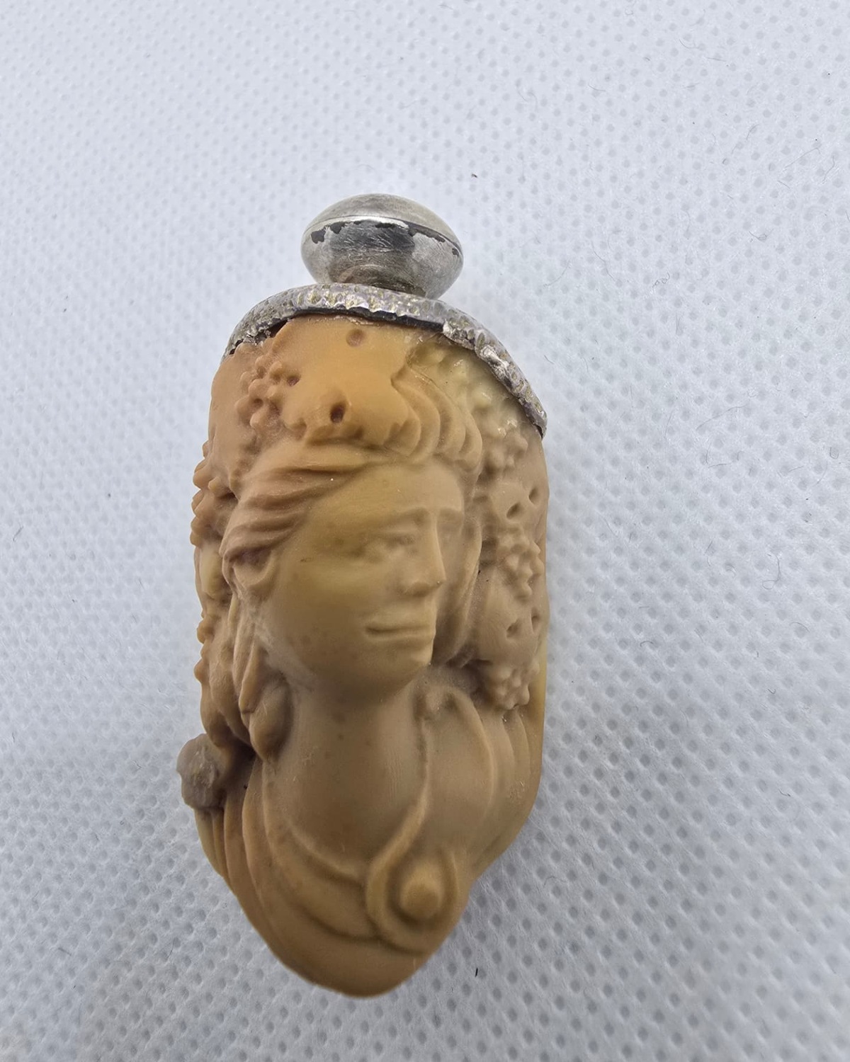 Carved cameo agate vessel with a woman's profile and silver cap, front view