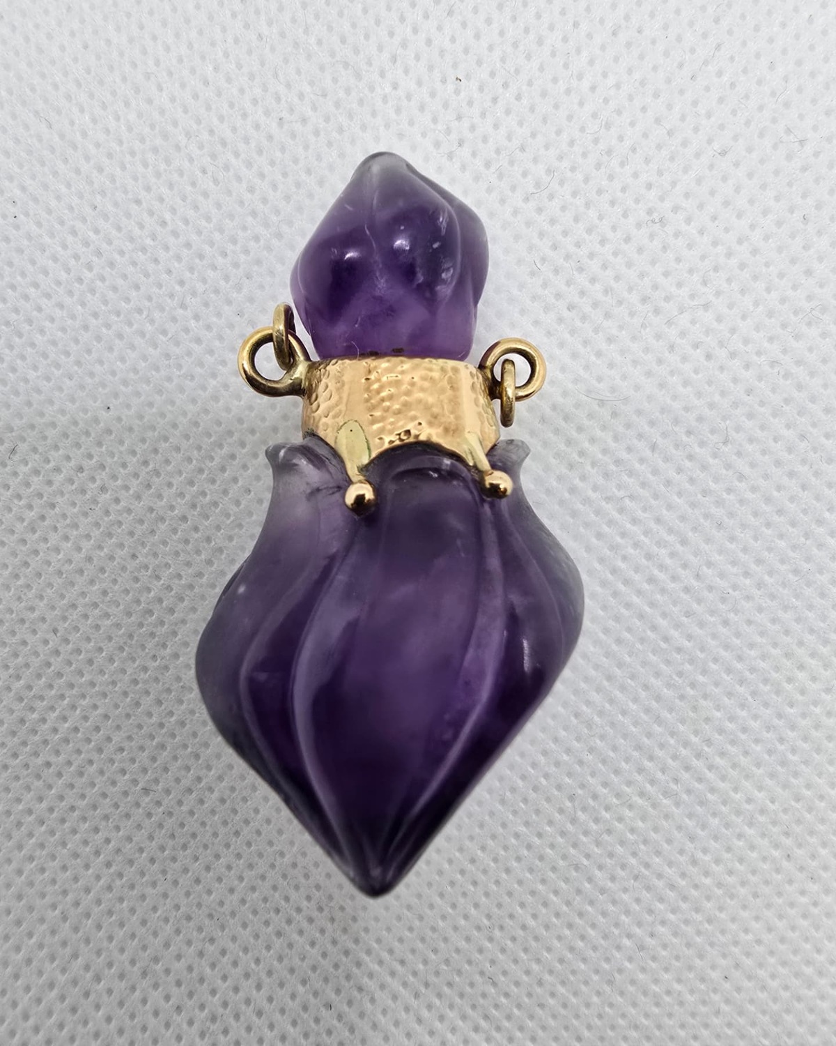 Carved amethyst vessel with hammered gold collar and gold prongs, front view