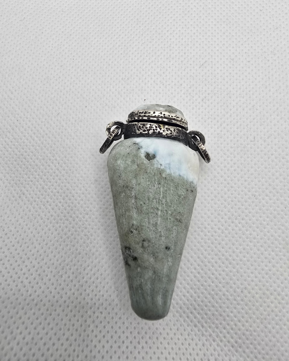 Hand-carved green and white stone vessel with hammered silver collar, front view