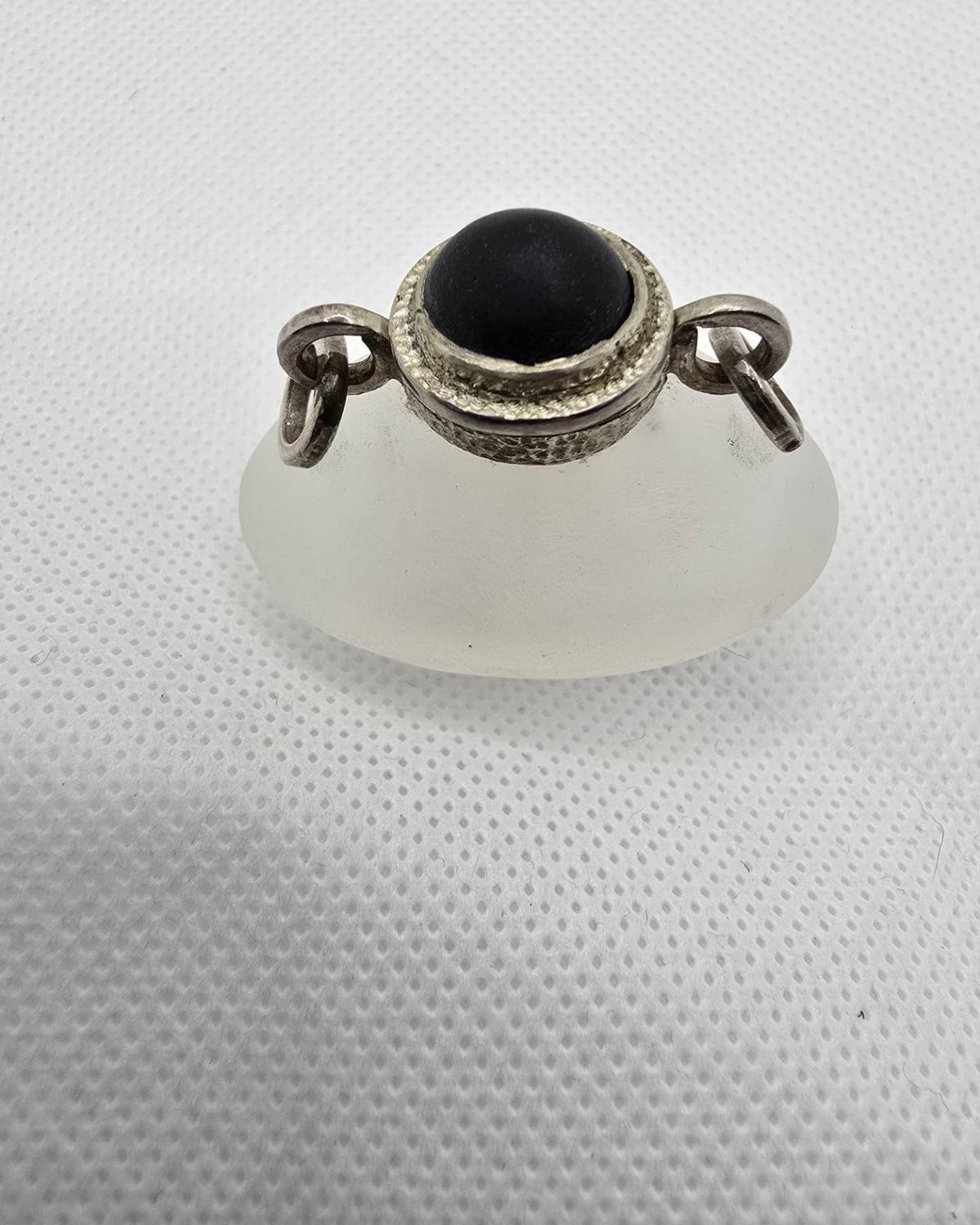 Frosted rock crystal heart vessel, angled view of the silver collar and stopper