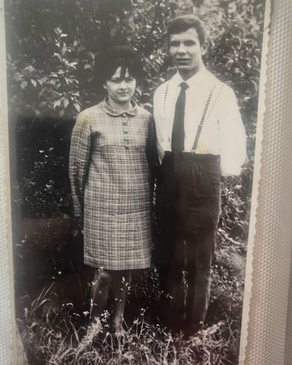 Black and white photograph of Grzegorz Kiernicki as a young man standing in a garden in Poland