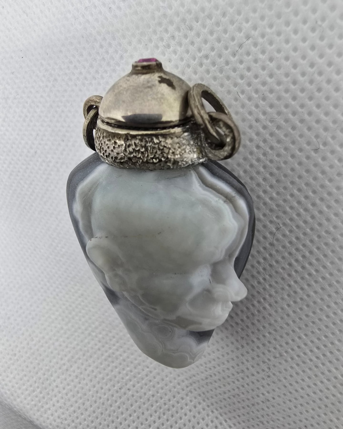 Hand-carved agate vessel with sculpted face, side view