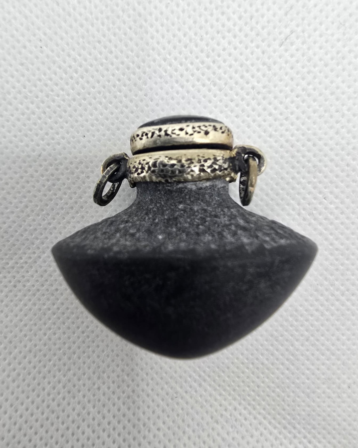 Hand-carved dark stone vessel with ornate silver metalwork, front view