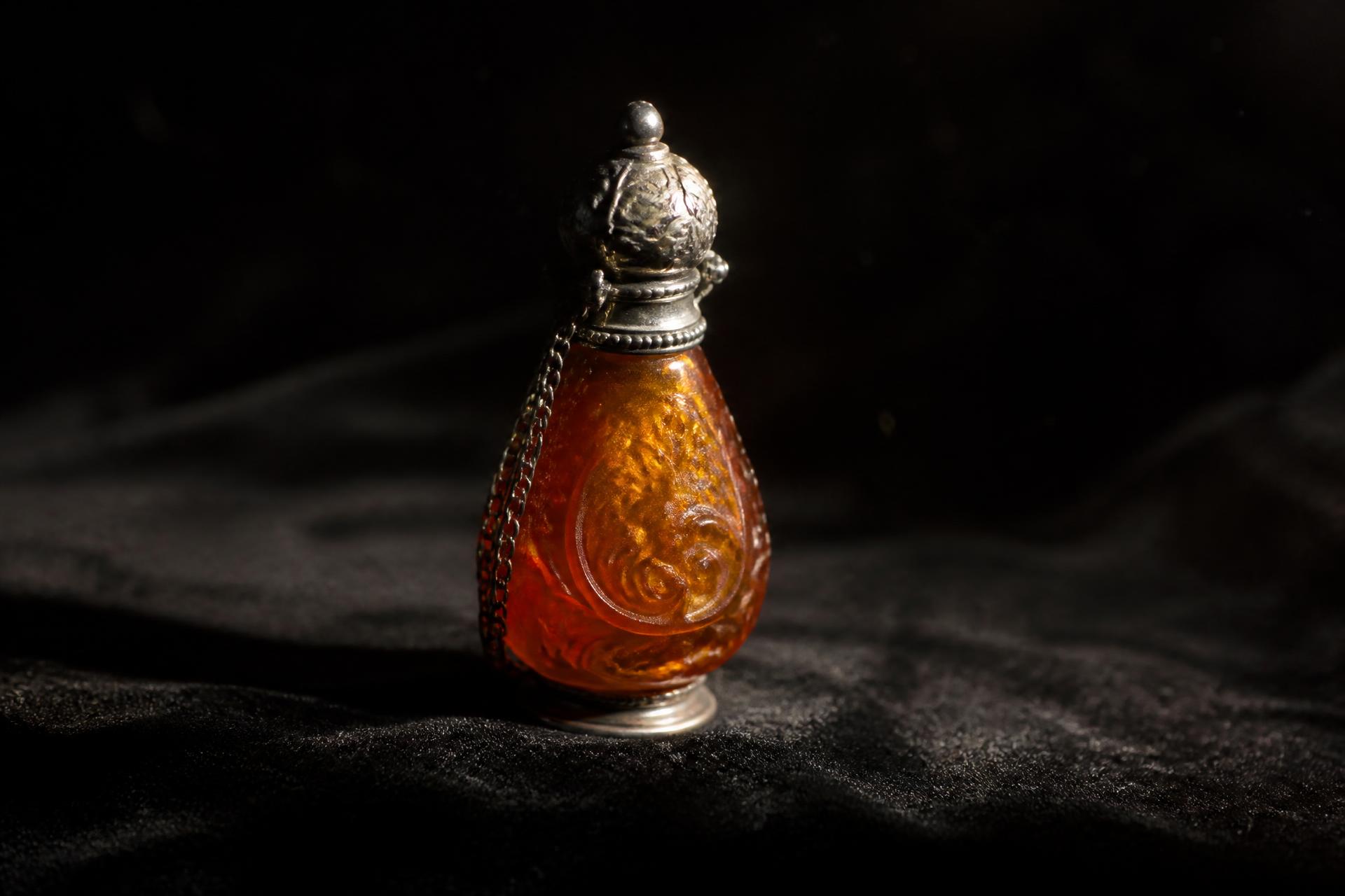 Hand-carved amber and silver vessel from the Grzegorz Collection, lit against a dark ground